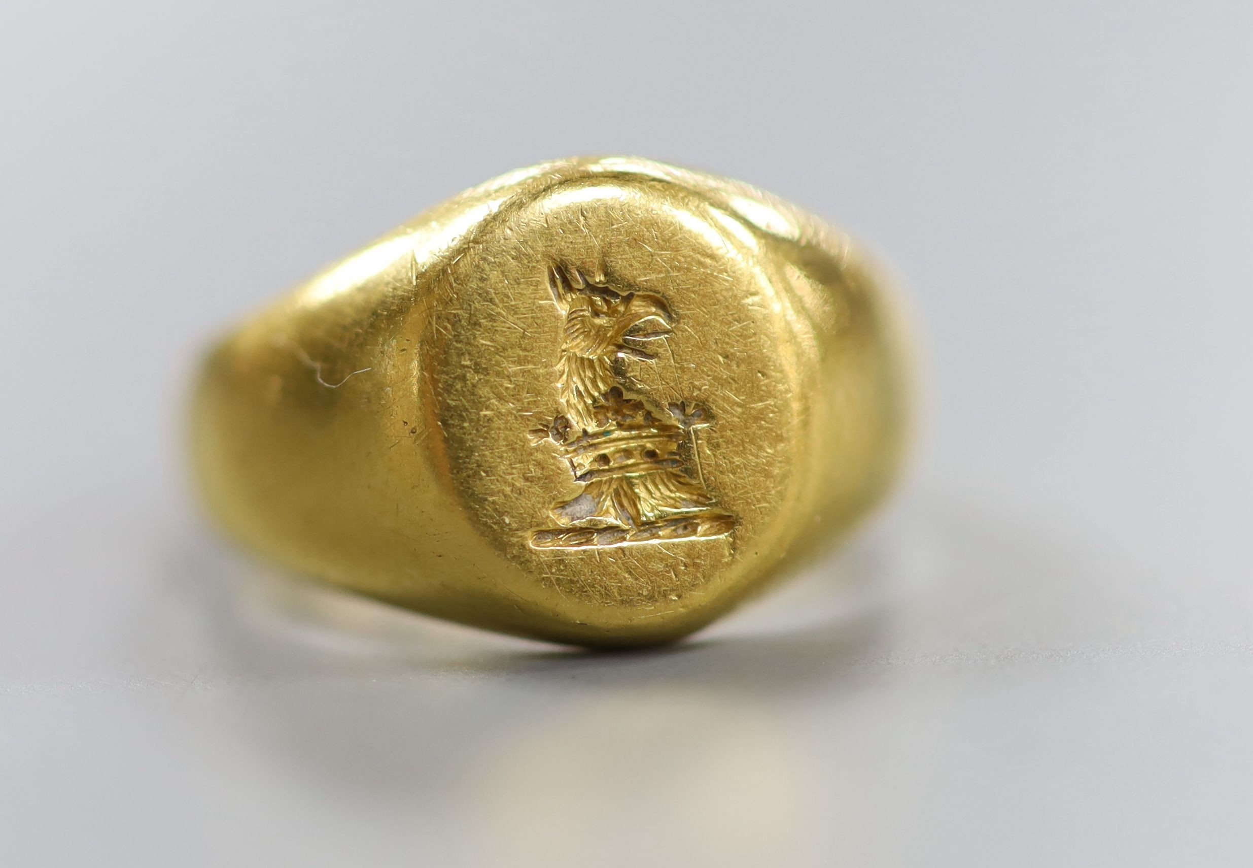 An early 20th century yellow metal(stamped 22) intaglio crested signet ring, size J, 8.6 grams.